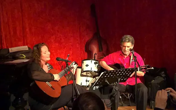 Tania Alon mit Gitarre und Band vor rotem Vorhang